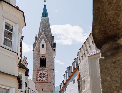 Campanile che si alza sopra una stretta via di Brixen Südtirol | © (c) Michael Pezzei