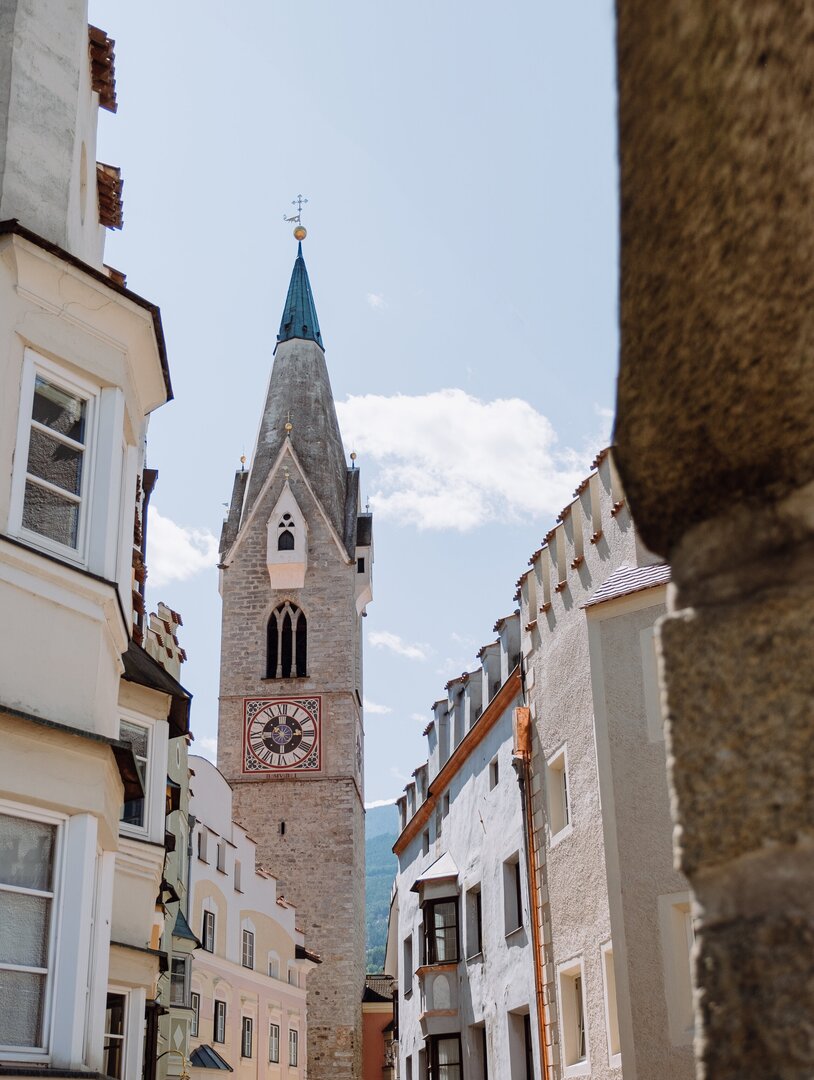 Campanile che si alza sopra una stretta via di Brixen Südtirol | © (c) Michael Pezzei