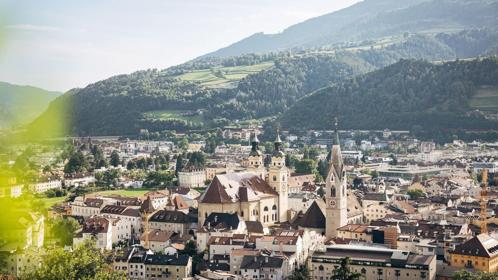 View over Brixen Südtirol with the old town, church towers and green mountain slopes.
