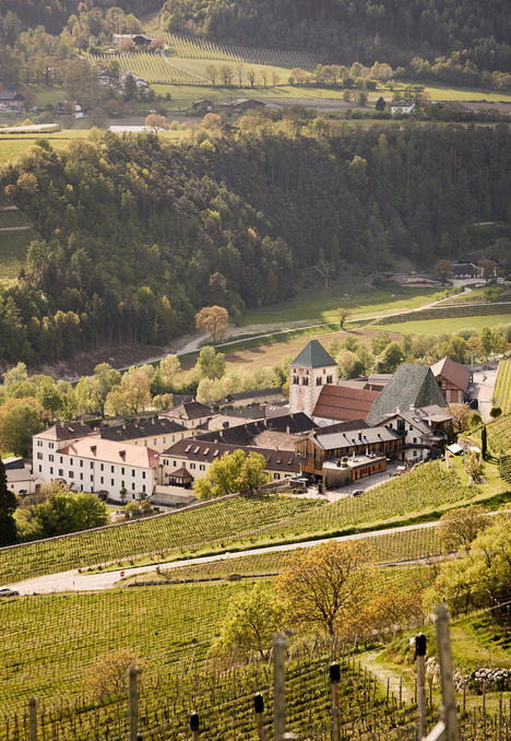 Blick auf ein Dorf in Brixen Südtirol, umgeben von Weinbergen und bewaldeten Hängen im Tal. | © Andreas Tauber