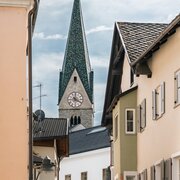 Schmale Altstadtgasse mit Kirchturm zwischen historischen Häusern in Brixen Südtirol.