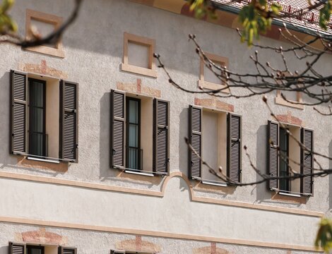 Facciata storica a Brixen Südtirol con persiane e rami spogli in primo piano | © Brixen Südtirol Dolomites Italy