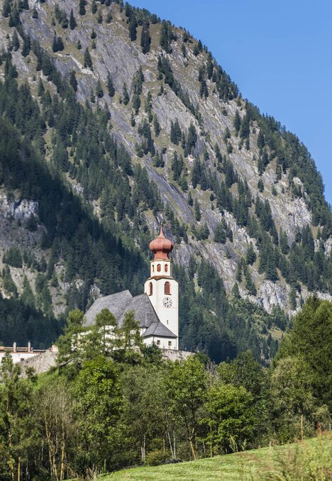 Kirche am Fuß eines steilen Berghangs in Brixen Südtirol