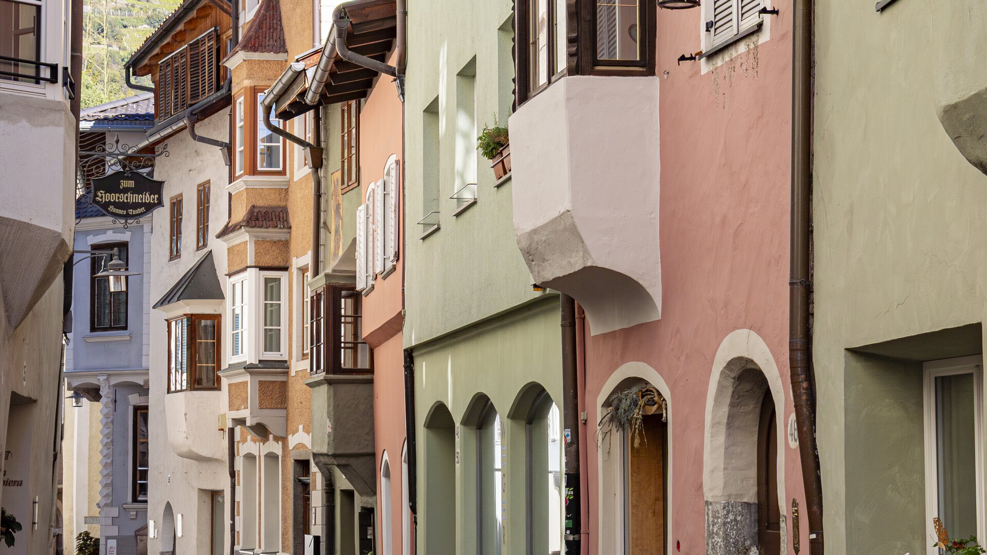 Enge Kopfsteinpflastergasse mit bunten historischen Häusern in Brixen Südtirol