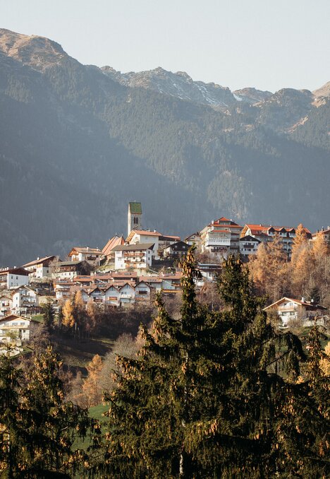 Bergdorf in Brixen Südtirol mit Häusern am Hang vor den Gipfeln.