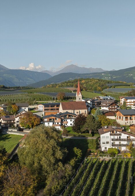 Paese con chiesa, vigneti e montagne a Brixen Südtirol