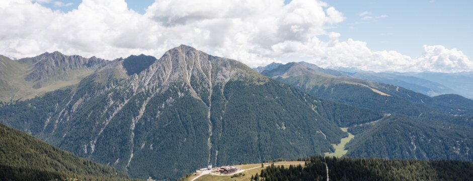 Alpine meadow with winding paths and mountain views on a sunny day