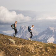 Due escursionisti su una cresta di montagna con vista panoramica sulle Alpi a Brixen Südtirol