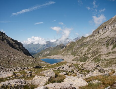 Lago alpino in una valle rocciosa di montagna sotto un cielo terso.