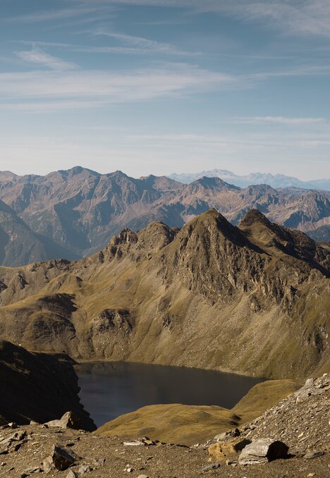Felsige Alpengipfel über einem kleinen Bergsee unter klarem blauem Himmel. | © IDM Südtirol-Alto Adige/Manuel Kottersteger
