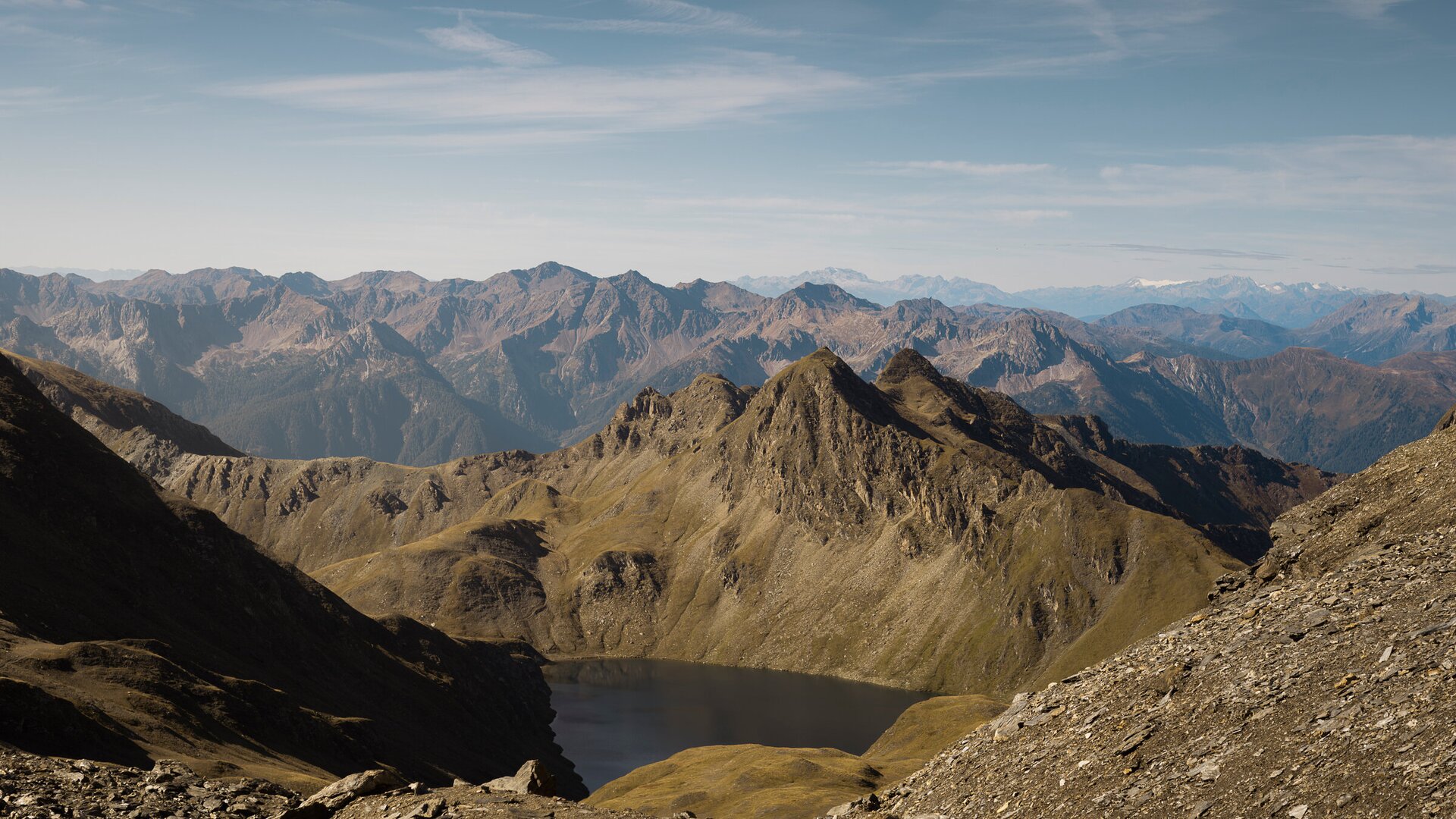 Cime alpine rocciose sopra un piccolo lago di montagna sotto un cielo azzurro limpido. | © IDM Südtirol-Alto Adige/Manuel Kottersteger