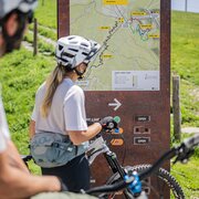 Ciclisti davanti alla mappa dei sentieri nel Brixen Bikepark a Brixen Südtirol.