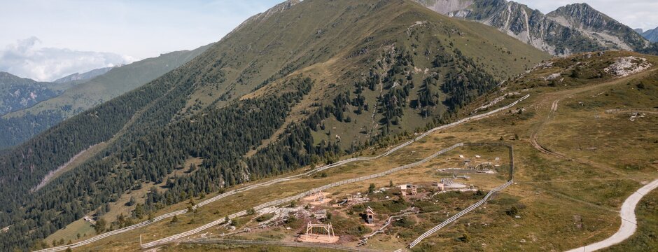 Sentiero di montagna sopra un lago turchese su un altopiano alpino verde