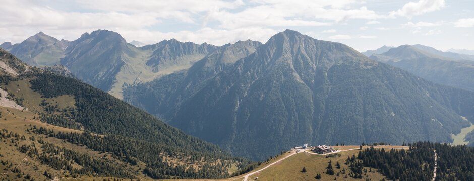 Sonniges Bergpanorama mit Almwiesen, Wanderwegen und markanten Gipfeln.