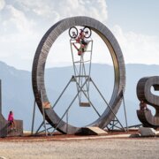 Persone vicino al simbolo PLOSE con vista sulle montagne a Brixen Südtirol.