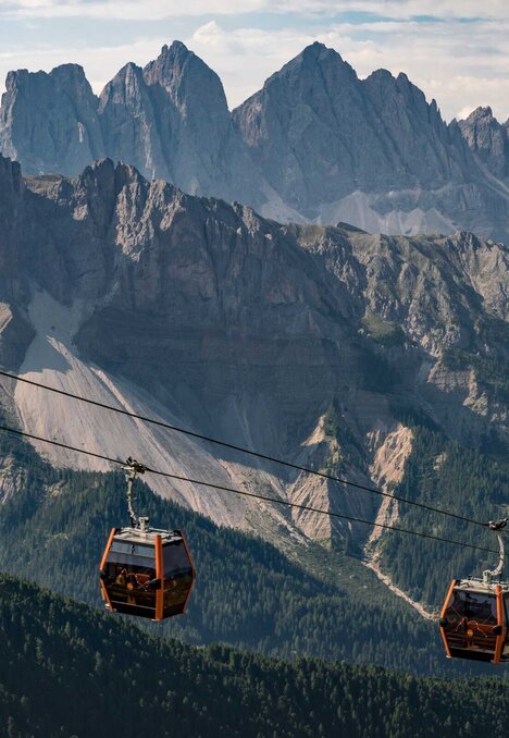 Le cabinovie scorrono sopra la valle con le cime frastagliate delle Dolomiti a Brixen Südtirol.