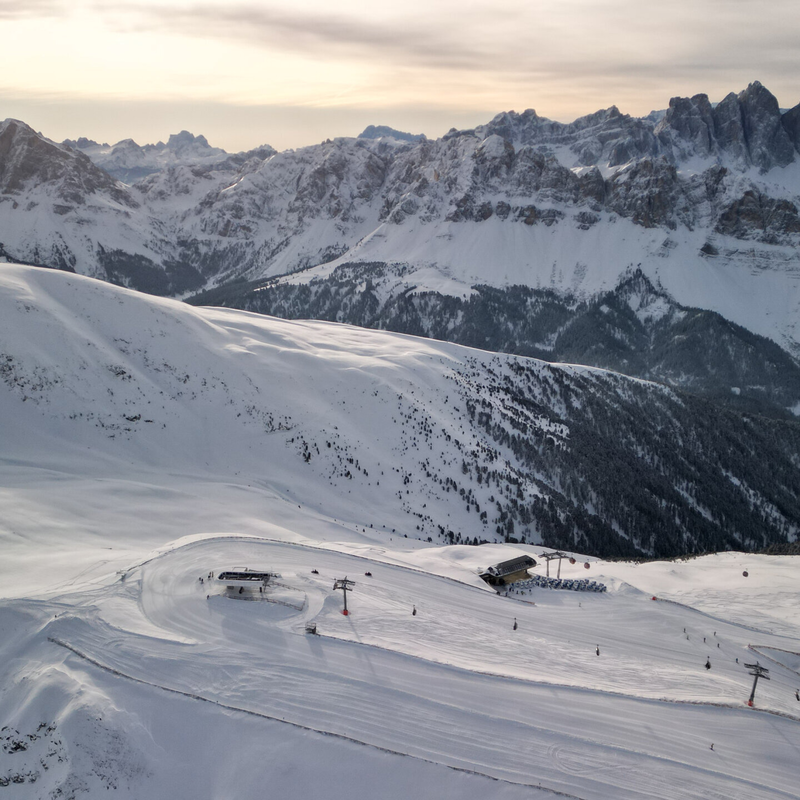 Besneeuwde hellingen onder ruige Alpentoppen in het eerste licht van de dag.