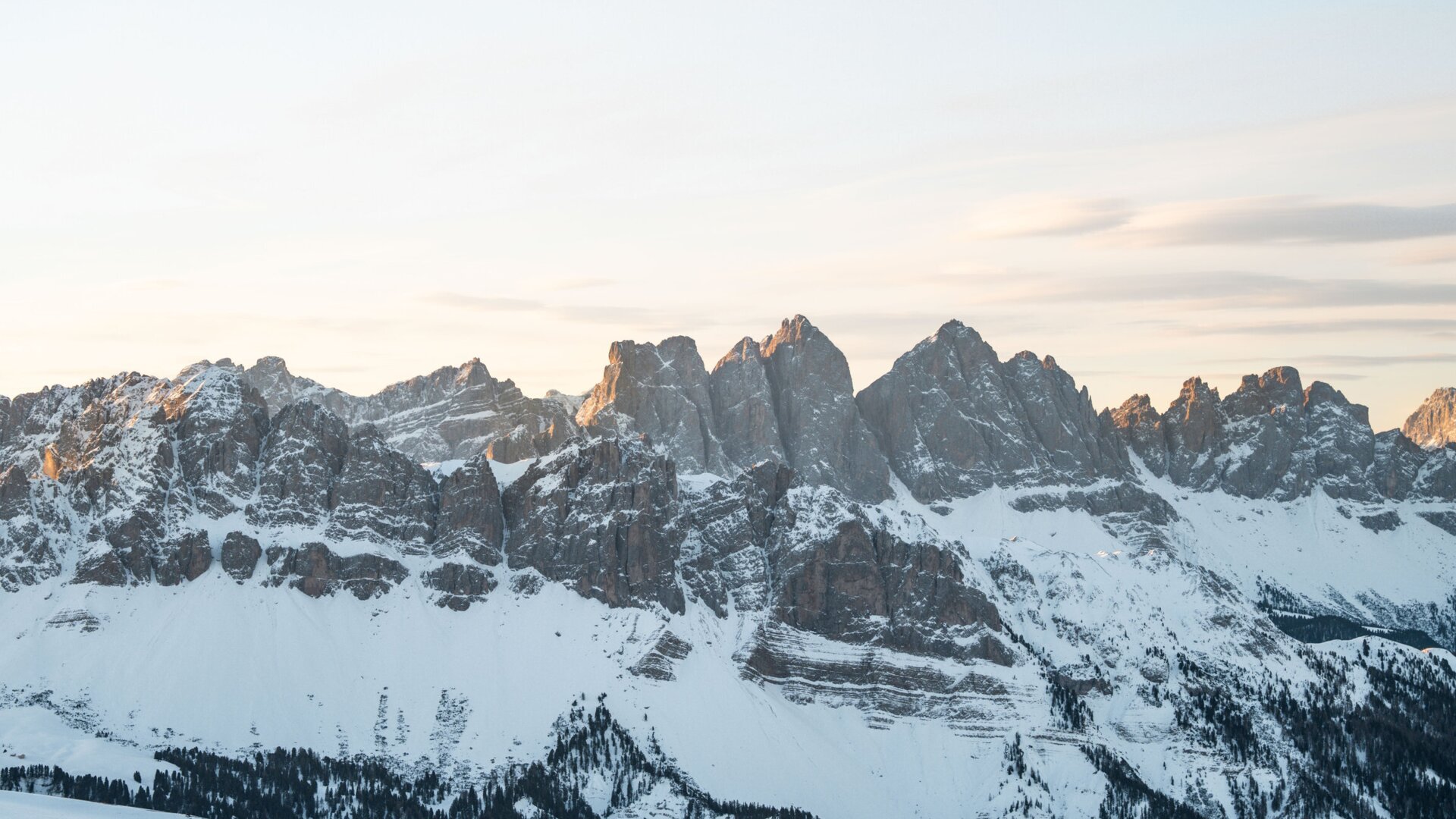Verschneite Gipfel über einem Tal im Morgenlicht in der Region Brixen Südtirol.