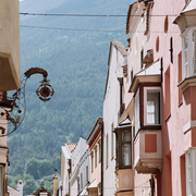 Vicolo stretto a Brixen Südtirol con facciate storiche e sfondo di montagna.