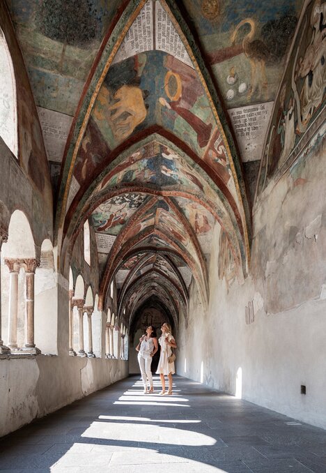 Corridoio del chiostro affrescato con archi a Brixen Südtirol, due persone camminano | © IDM Südtirol-Alto Adige/Alex Filz
