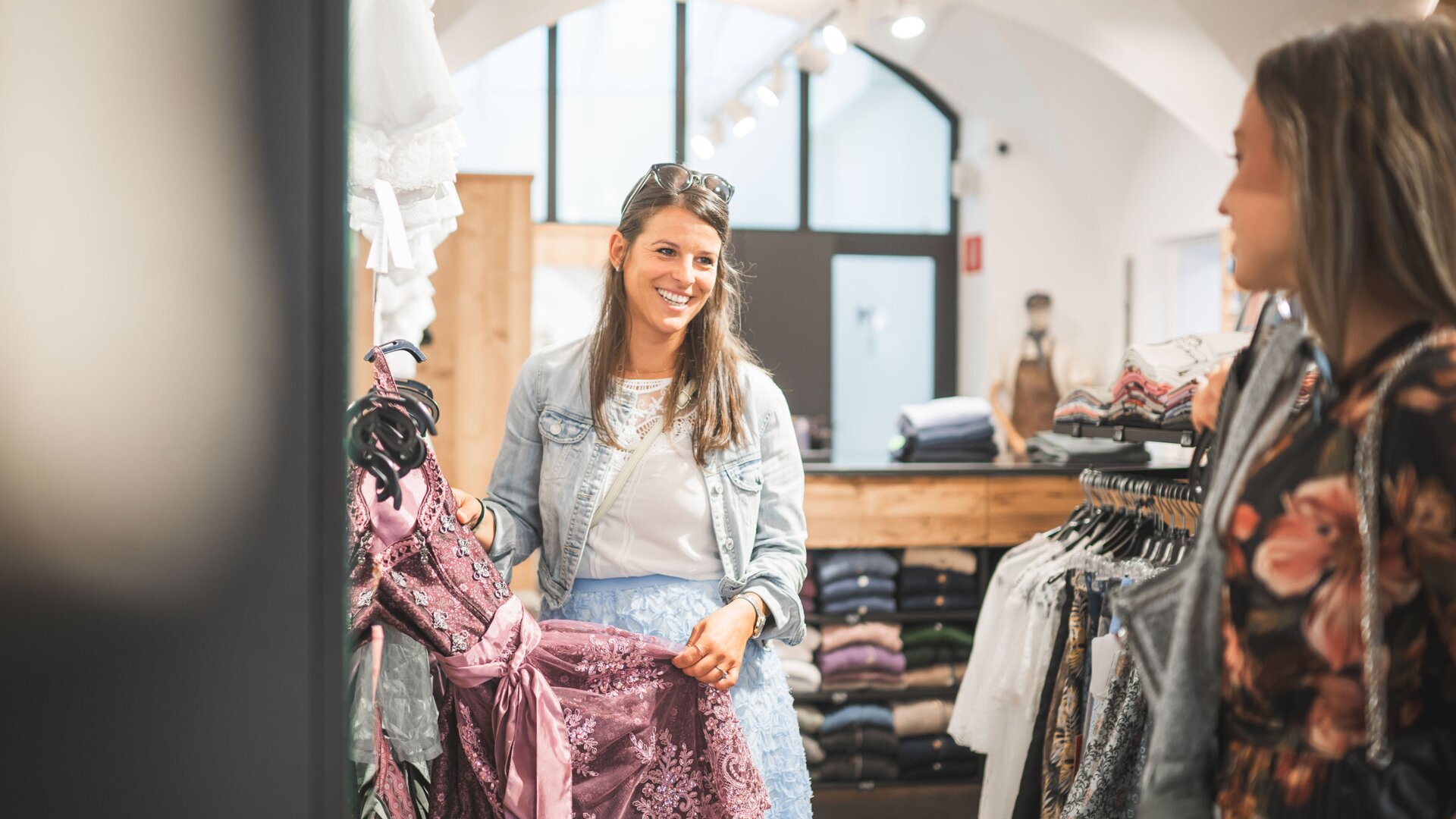 Two women browsing dresses in a boutique in Brixen Südtirol.