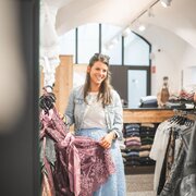 Due donne guardano degli abiti in una boutique a Brixen Südtirol.