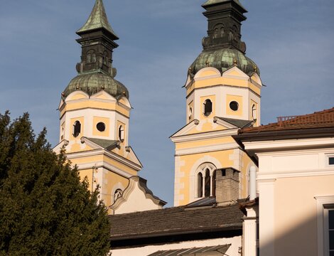 Due campanili con cupole a cipolla si alzano sopra gli edifici storici sotto un cielo azzurro.