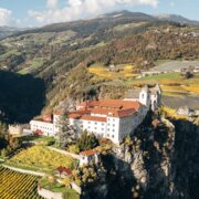 Un monastero su uno sperone roccioso sopra i vigneti e la valle a Brixen Südtirol.