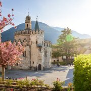 Castello storico a Brixen Südtirol con alberi in fiore e sfondo alpino