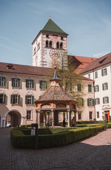 Historic courtyard with a tower and small pavilion in Brixen Südtirol.