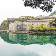 Forte in pietra riflesso in un lago di montagna tranquillo a Brixen Südtirol.