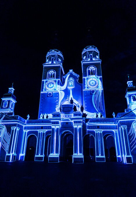 Domfassade in leuchtend blauem Licht vor dunklem Nachthimmel. | © (c) Michael Pezzei