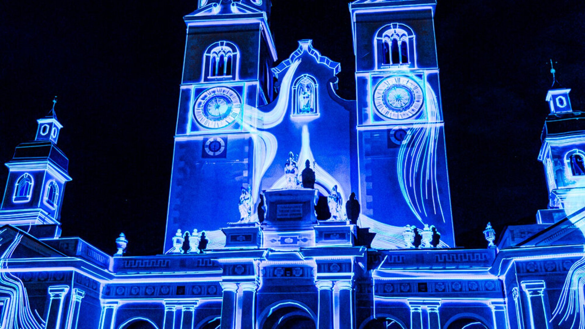 Cathedral façade illuminated in bright blue light against a dark night sky. | © (c) Michael Pezzei
