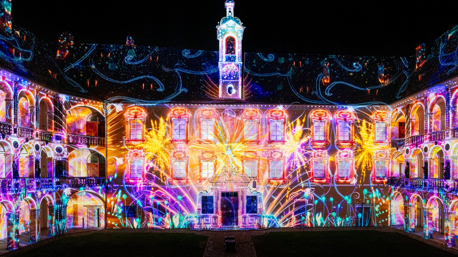 Colorful light projections on a historic courtyard building at night in Brixen Südtirol.