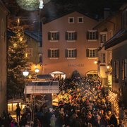 Crowded night market in Brixen Südtirol’s old town with warm lights and a festive atmosphere.